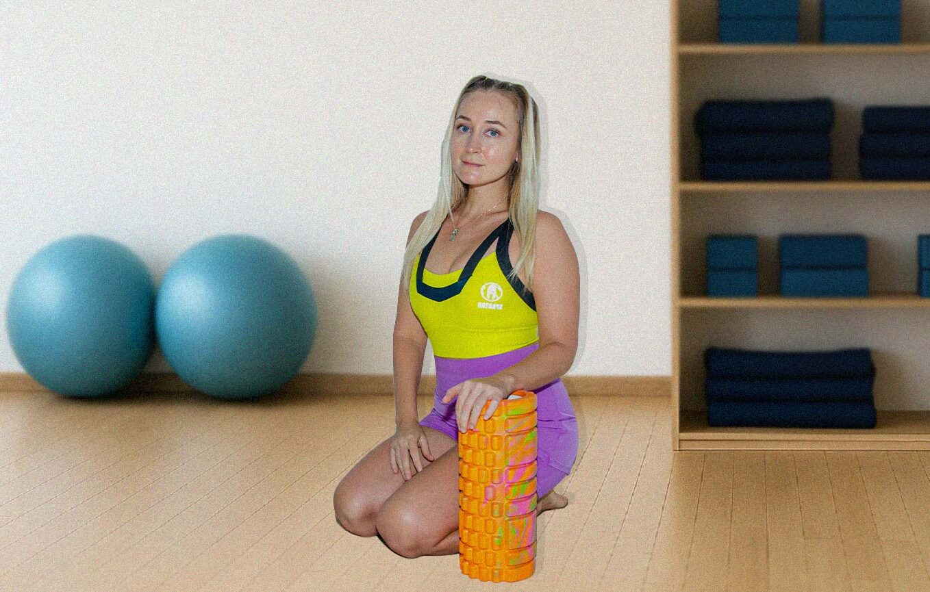 Portrait of a female movement and recovery specialist sitting in a fitness studio with exercise props in the background